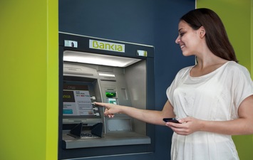 Girl withdrawing cash from an ATM Bankia