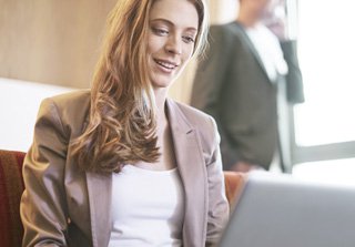 Girl blonde with brown jacket with the laptop