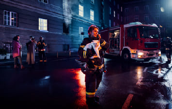 firefighter carrying a cat