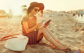 Girl in the beach with card and mobile phone in the hand