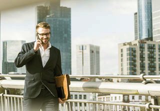 Employer crossing bridge and talking for mobile phone