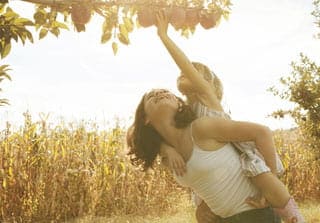 Girl on someone's back to gather fruit