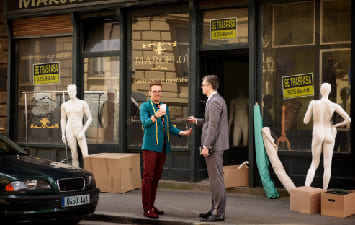 Tailor in front of a business premises